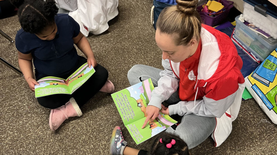 student-athlete reading to child