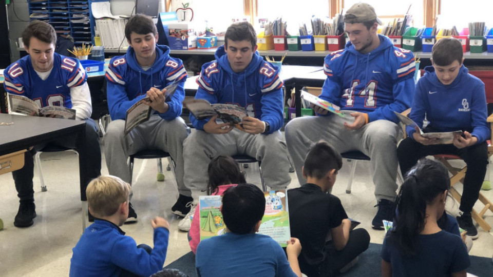 Student-athletes reading to children