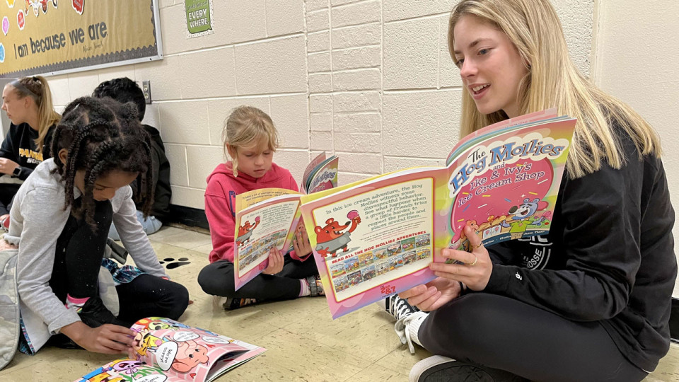 student-athlete reading to children