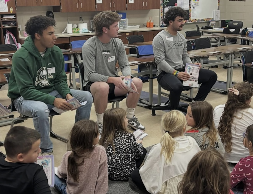 Student-athletes reading to children