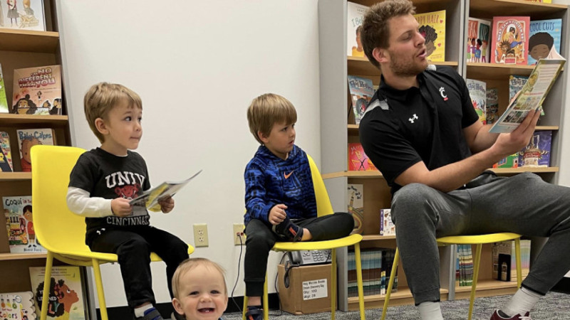 student athlete reading with children